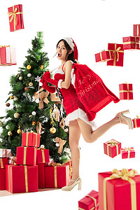 圣诞高跟鞋摄影照片_穿着圣诞服的年轻女人和圣诞礼物
