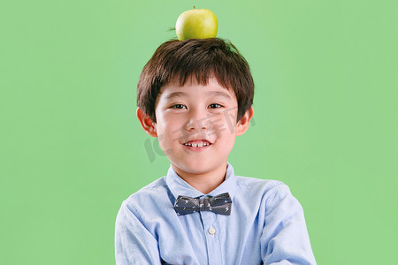小男孩头上顶着一个苹果