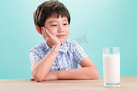 男孩表情包摄影照片_小男孩看着一杯牛奶