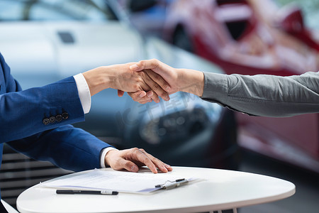 汽车产业摄影照片_汽车销售人员与顾客握手
