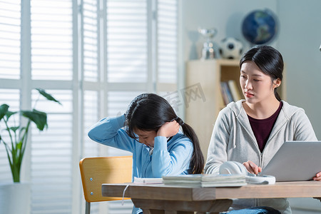 母女争吵摄影照片_年轻妈妈和做作业的女儿生气