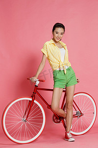 青年女人斜靠着自行车