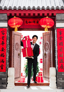 新年灯笼金色摄影照片_抱着礼物盒的青年男人