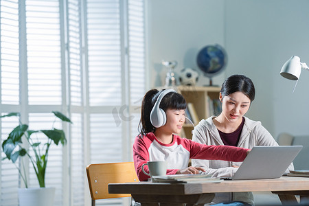 年轻妈妈辅导女儿上网课