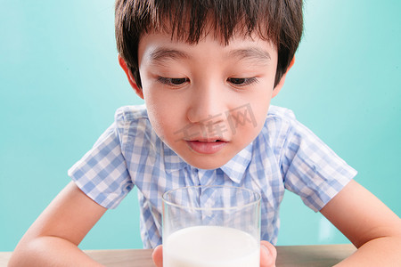 小男孩看着一杯牛奶