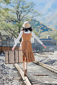 背影行走摄影照片_青年女人在铁轨上行走