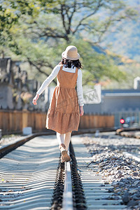青年女人在铁轨上行走