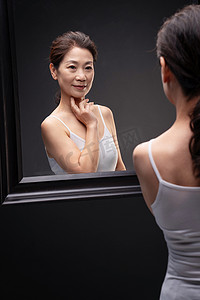 漂亮的中年女性欣赏镜子中的自己