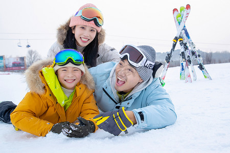 快乐的一家三口趴在雪地上