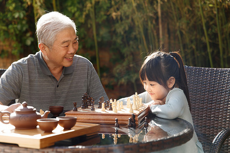 祖父和孙女在庭院里下棋