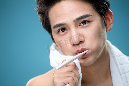 年轻男人用毛巾擦刷牙时脸上的泡沫