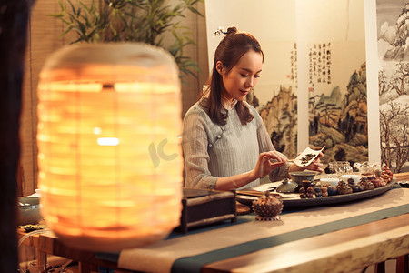 中式民俗画摄影照片_青年女人展示茶艺