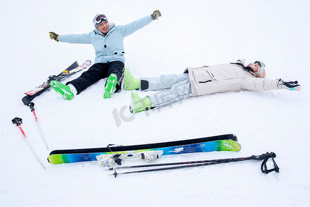 青年伴侣放松的躺着坐着在雪地上