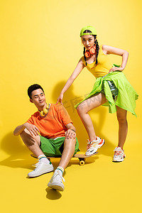 绿色的运动鞋摄影照片_青年伴侣一起玩滑板