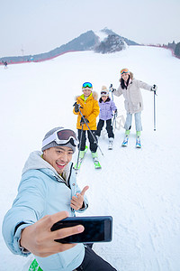 滑雪场上用手机自拍的一家四口