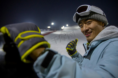 夜晚青年男人站在滑雪场内