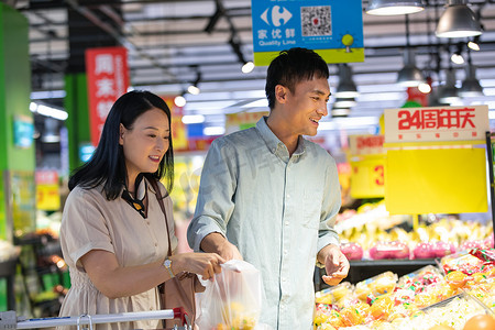 水果超市促销摄影照片_中年夫妇在超市挑选水果