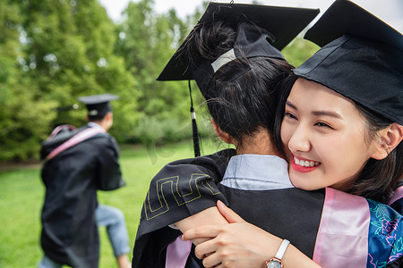 新同学新同学摄影照片_户外穿着学士服的大学生拥抱庆祝