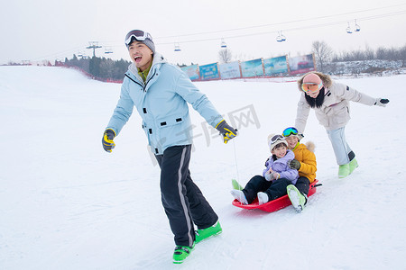 玩雪上滑板幸福的一家四口