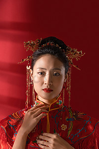 古典背景摄影照片_整理衣领的漂亮中式新娘