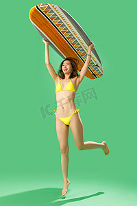 穿比基尼的美女举着冲浪板