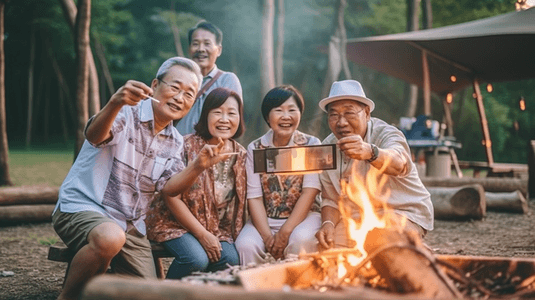 卡通拍照框摄影照片_亚洲老人用智能手机给他的家人拍照，他们在湖边旅行和野餐，他们露营，用炉子烧烤，幸福的家庭活动