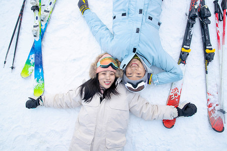 快乐的青年伴侣躺在雪地上