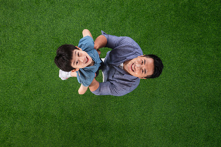 儿童托举摄影照片_草地上快乐的父子俩