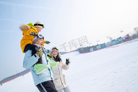 雪地玩耍人物摄影照片_来滑雪场度假的三口之家