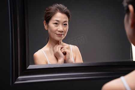 中年女性中国摄影照片_中年女性欣赏镜子中的自己