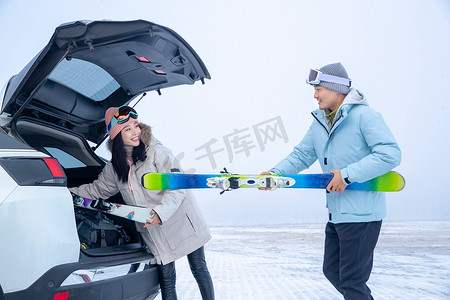 青年夫妻摄影照片_青年夫妻往汽车后备箱里装滑雪板