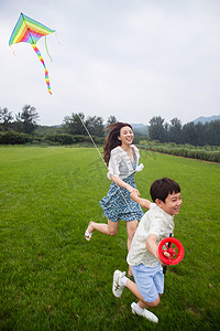 风筝摄影照片_快乐的母子在草地上放风筝