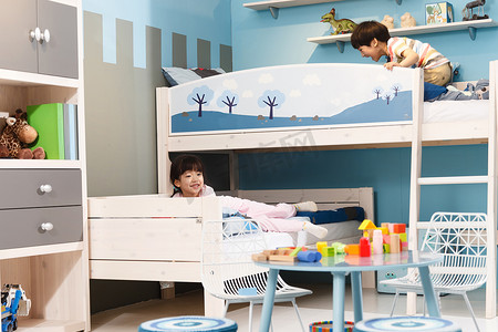 卡通蓝色家具摄影照片_两个孩子在上下铺床上玩耍