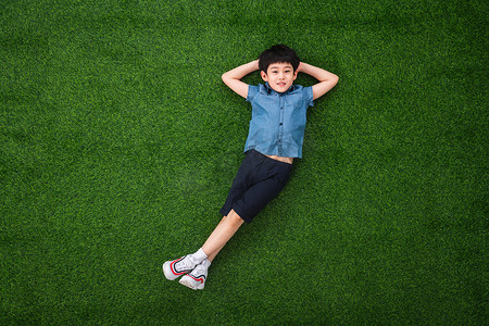 躺着的人像摄影照片_可爱的小男孩躺在草地上