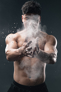 疫情防控青年摄影照片_举重运动员往手上涂抹滑石粉