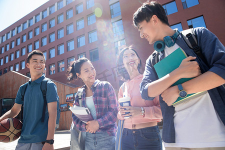 梦想阳光摄影照片_阳光下四个大学生在校园里边走边聊