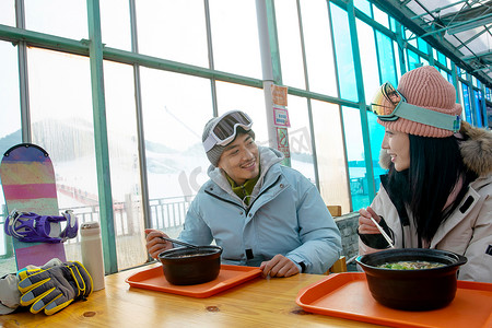 滑雪完的青年伴侣在餐厅用餐