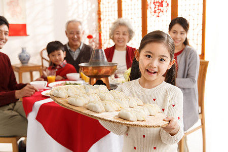 冬至团圆摄影照片_小女孩过年端着饺子