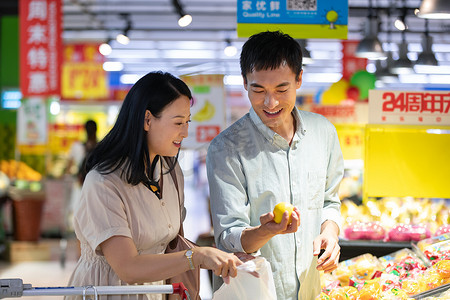 水果超市促销摄影照片_中年夫妇在超市挑选水果