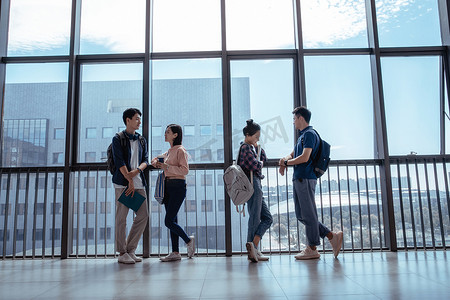 窗户白云摄影照片_教学楼里大学生靠在窗户前聊天