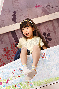 窗帘卡通摄影照片_可爱的小女孩在床上玩耍