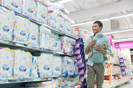 小超市摄影照片_抱着小婴儿的中年男性在超市购物