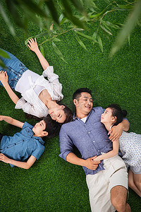 幸福的一家四口躺在草地上