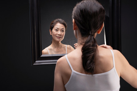 中年女性中国摄影照片_中年女性欣赏镜子中的自己