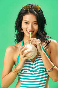清爽一夏天摄影照片_喝椰子汁的泳装美女肖像