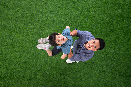 儿童托举摄影照片_草地上快乐的父子俩