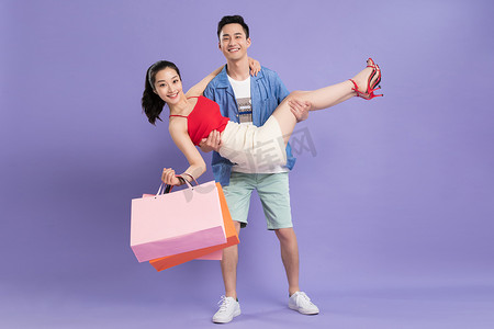 紫色浪漫情侣背景摄影照片_快乐的青年情侣购物