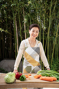 木质案板摄影照片_庭院内准备食材的中年女性肖像
