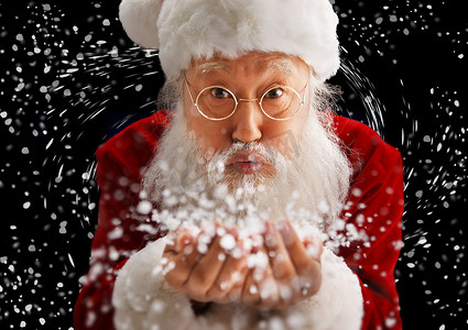 圣诞老人胡子帽子摄影照片_圣诞老人捧着雪在吹