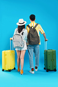 旅行背影摄影照片_青年情侣拉着行李箱去旅游的背影